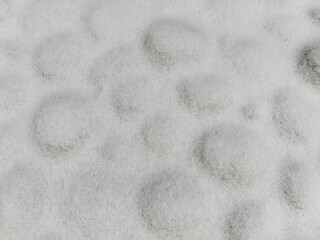 Round stones covered with a thin layer of snow.