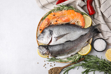 Different fresh sea food with spices on light grey table, flat lay. Space for text