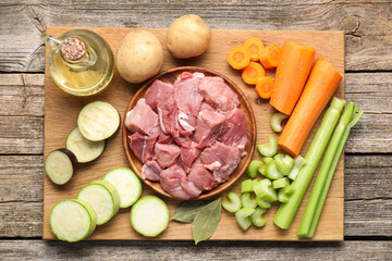 Cooking stew. Uncooked meat and vegetables on wooden table, top view