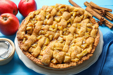 Homemade apple pie and ingredients on light blue wooden table, closeup