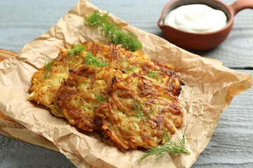 Delicious potato pancakes served on grey wooden table, closeup