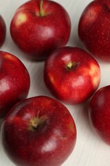 Fresh ripe red apples on white wooden table, closeup