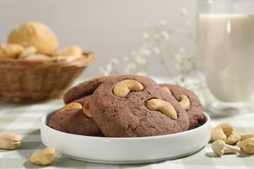 Tasty chocolate cookies with cashew on table, closeup