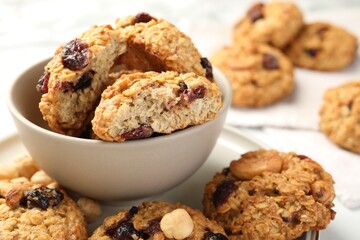Delicious oatmeal cookies with raisins and nuts on table, closeup