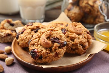 Delicious oatmeal cookies with raisins and nuts on table, closeup