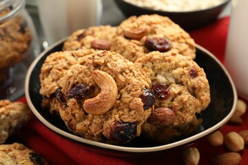 Delicious oatmeal cookies with raisins and nuts on table, closeup