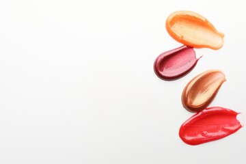 Smears of different lip products on white background, top view