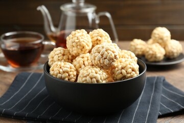 Tasty puffed rice balls in bowl on table, closeup