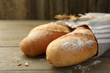 Freshly baked baguettes on wooden table, closeup