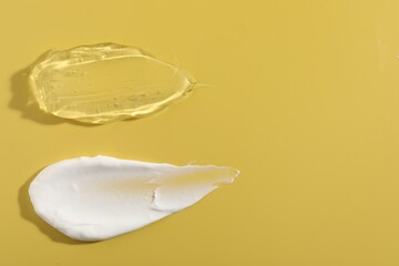 Samples of different cosmetic products on yellow background, top view. Space for text