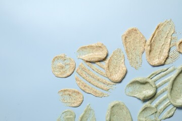Samples of body scrubs on light background, flat lay. Space for text