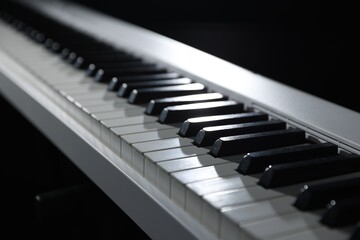 Synthesizer on black background, closeup. Electronic musical instrument