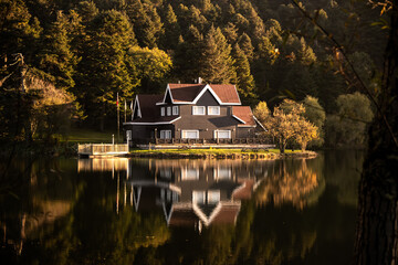 Obraz premium House by the lake at Bolu Gölcük in autumn. Stunning reflections on the calm waters create a picturesque scene.