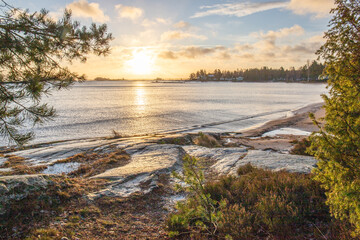 Shore of a lake at sunrise. Landscape shot in the Narur in the morning. Forests lake and water at the beginning of winter or in autumn. Sweden, Scandinavia