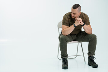 Thoughtful man sitting on a chair in casual outfit
