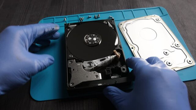 repairman fixing computer hard disk drive in service center