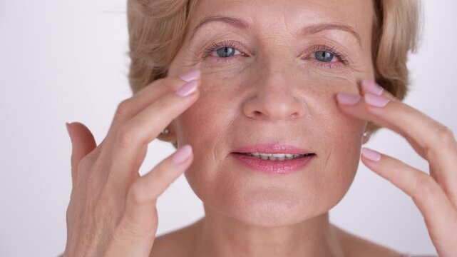 Closeup portrait of a charming middle-aged female who lovingly takes care of her skin, embracing the essence of selflove and confident aging