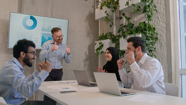 Diverse multinational business company colleagues team co-workers celebrate achievement victory happy joyful businessmen and businesswoman in boardroom office partnership teamwork win successful deal