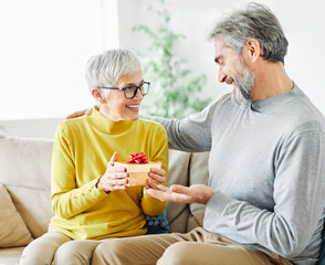 gift woman man couple happy love happiness present kiss romantic smiling together box wife husband elderly old senior mature retired