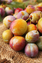 Pile of tasty ripe plums on table, closeup