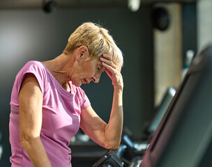 gym sport fitness exercising training mature senior elderly woman running cardio treadmill tired exhausted resting fatigue break challenge healthy active workout run