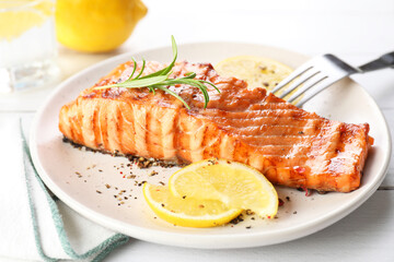 Delicious grilled salmon fillet served on white wooden table, closeup