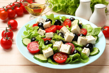 Delicious salad with feta cheese served on white wooden table, closeup