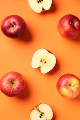 Whole and cut fresh red apples on orange background, flat lay
