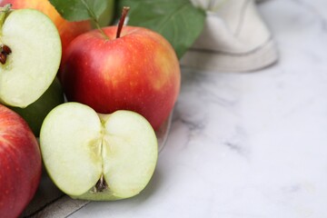 Different ripe apples on white table, closeup. Space for text