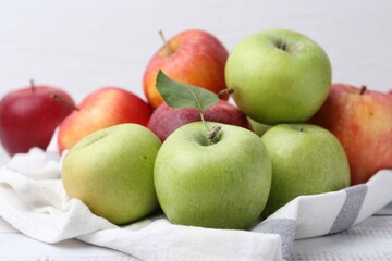 Different whole ripe apples on white wooden table, closeup