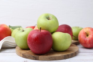 Different whole ripe apples on white wooden table