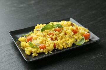Delicious pumpkin risotto on black table, closeup