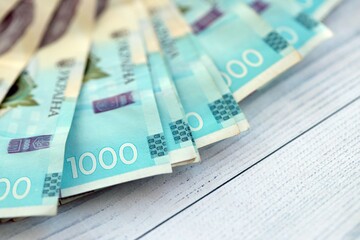 Big amount of ukrainian new one hundred hryvnia money bills with modern design on white wooden table. Financial concept, business