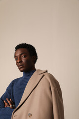 Vertical studio portrait of African American young man posing indoor. Vertical mock-up.