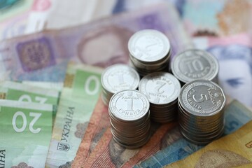 Few stacks of ukrainian money coins lies on old hryvnia banknotes