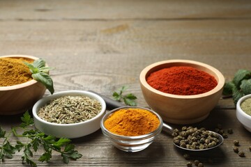 Different aromatic spices on wooden table, closeup. Space for text