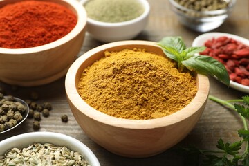 Different aromatic spices on wooden table, closeup