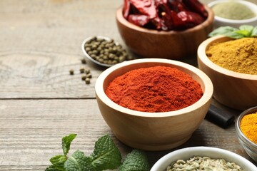 Different aromatic spices on wooden table, closeup. Space for text