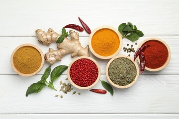 Different aromatic spices on white wooden table, flat lay