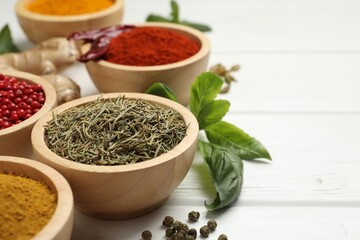 Different aromatic spices on white wooden table, closeup