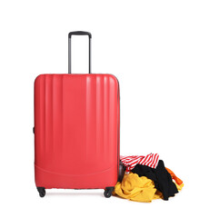 Red suitcase and messy pile of clothes isolated on white