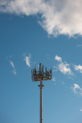 5g mobile network communication tower with cellular antenna transmitter and receiver, broadcasting 4g lte equipment, phone network station on sky with clouds background