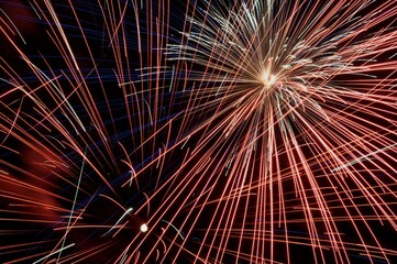 Red and white light of fireworks bursting at night
