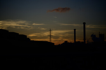 Naklejka premium sunset over an industrial city