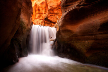 Slow shutter speed of waterfall in majestic red rock chasm