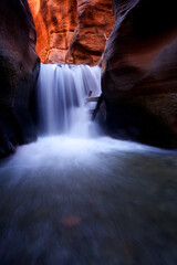 Vertical, slow shutter speed of majestic waterfall in chasm