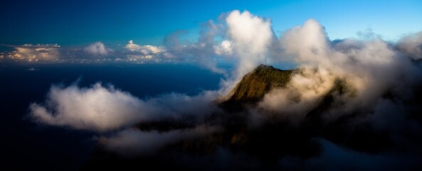 Low storm clouds over majestic Hawaiian mountain near ocean, high shot © DevinSuperTramp