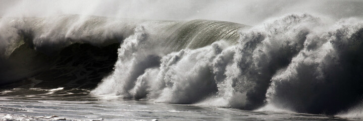 Crashing ocean wave creating mist and foam, closeup
