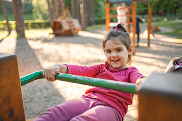 Active cute little girl on the playground