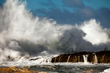 Massive splash of ocean water over rocky patch in Hawaii